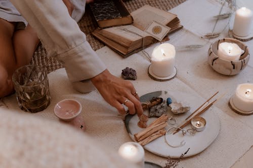 Woman Hand on Plate with Wax Candles around