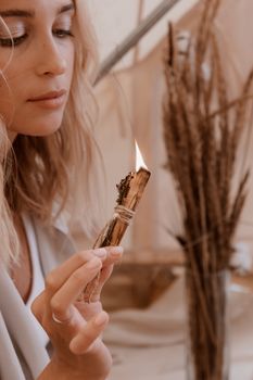 一位安静的女子在室内用燃烧的圣痕棒进行净化仪式