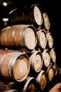 High pile of heavy timber kegs decomposed in row in light empty storage