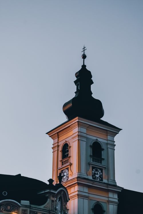 Free From below of old church building with cross on dome over clocks in overcast weather Stock Photo
