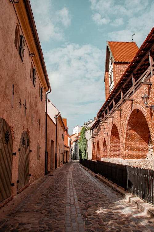 Photograph of a Road Between Brown Buildings