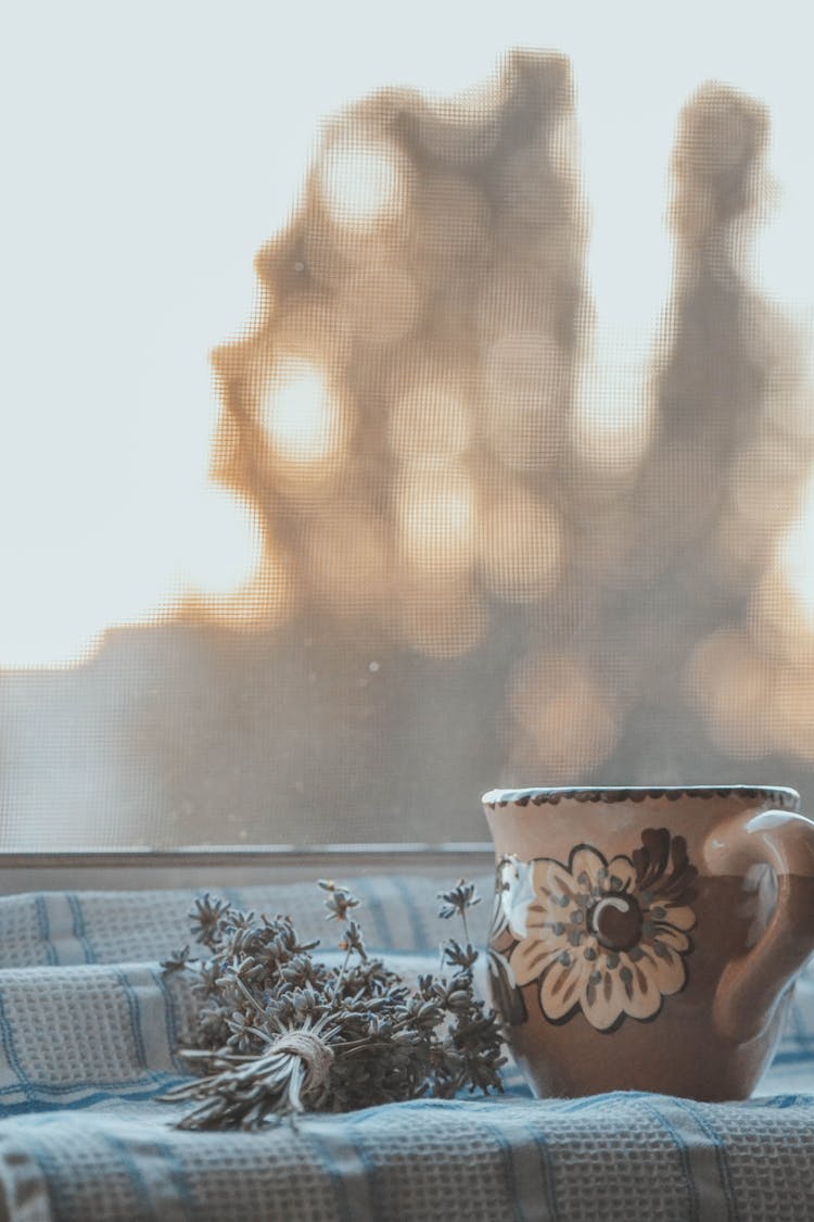 Brown Floral Ceramic Mug On Blue And White Textile