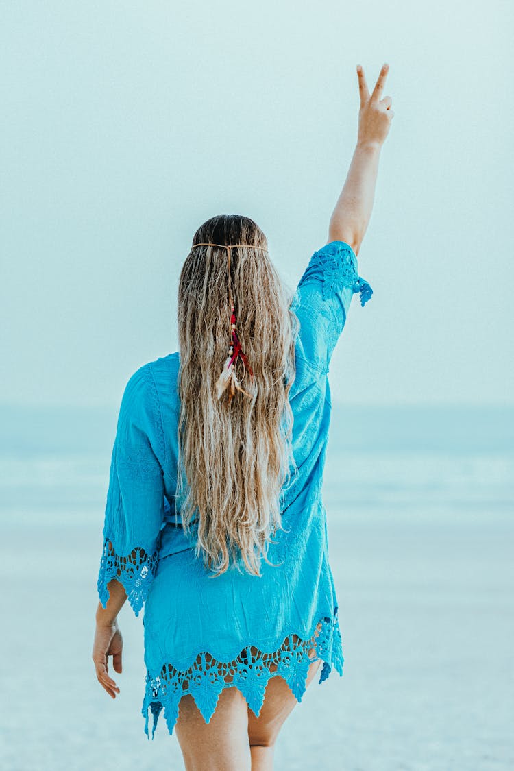 Woman In Blue Dress Wearing Feather Headwear Doing Peace Sign