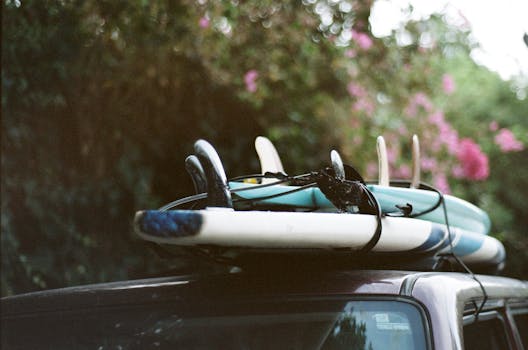 A stack of surfboards securely tied onto a car roof, ready for a summer adventure.