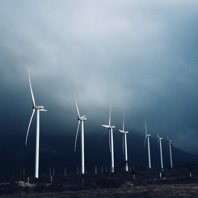 White Wind Turbines Under White Clouds