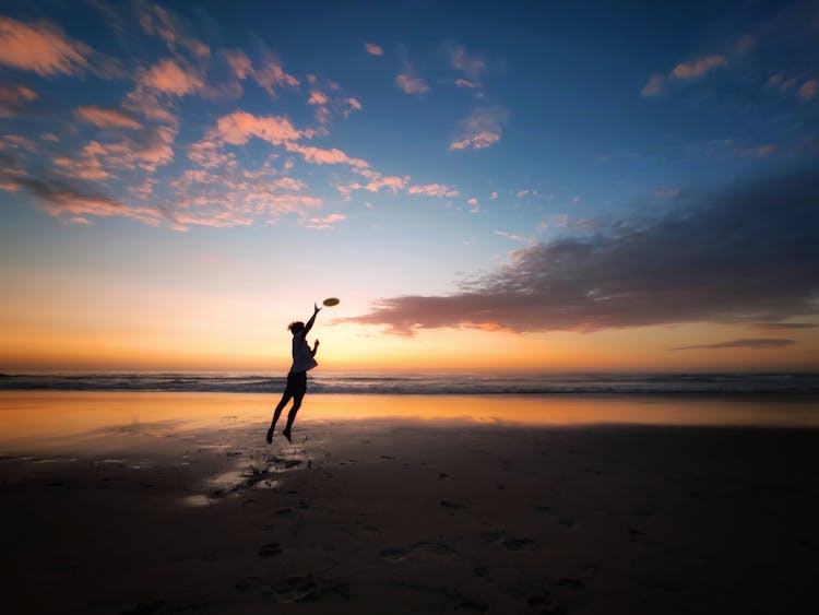 Person Catching Frisbee On Air