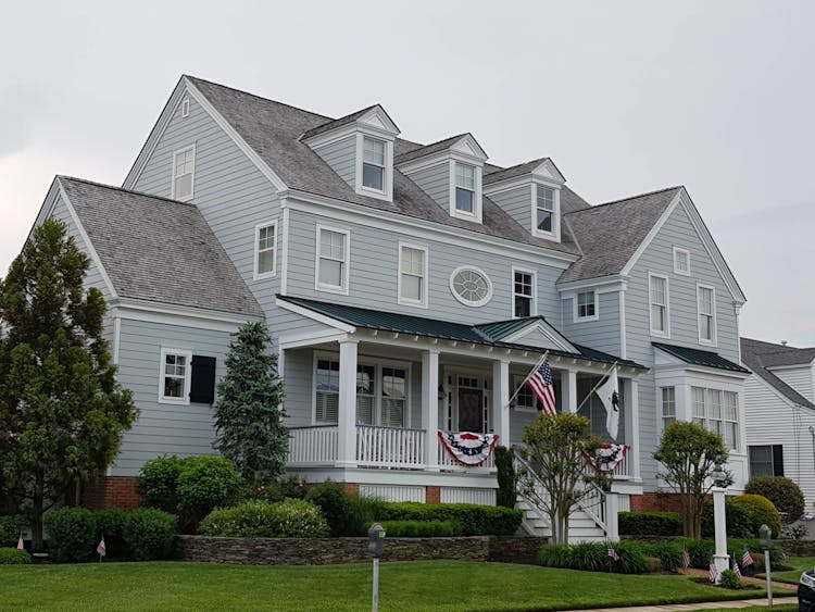 Blue And Gray Wooden House With Flags