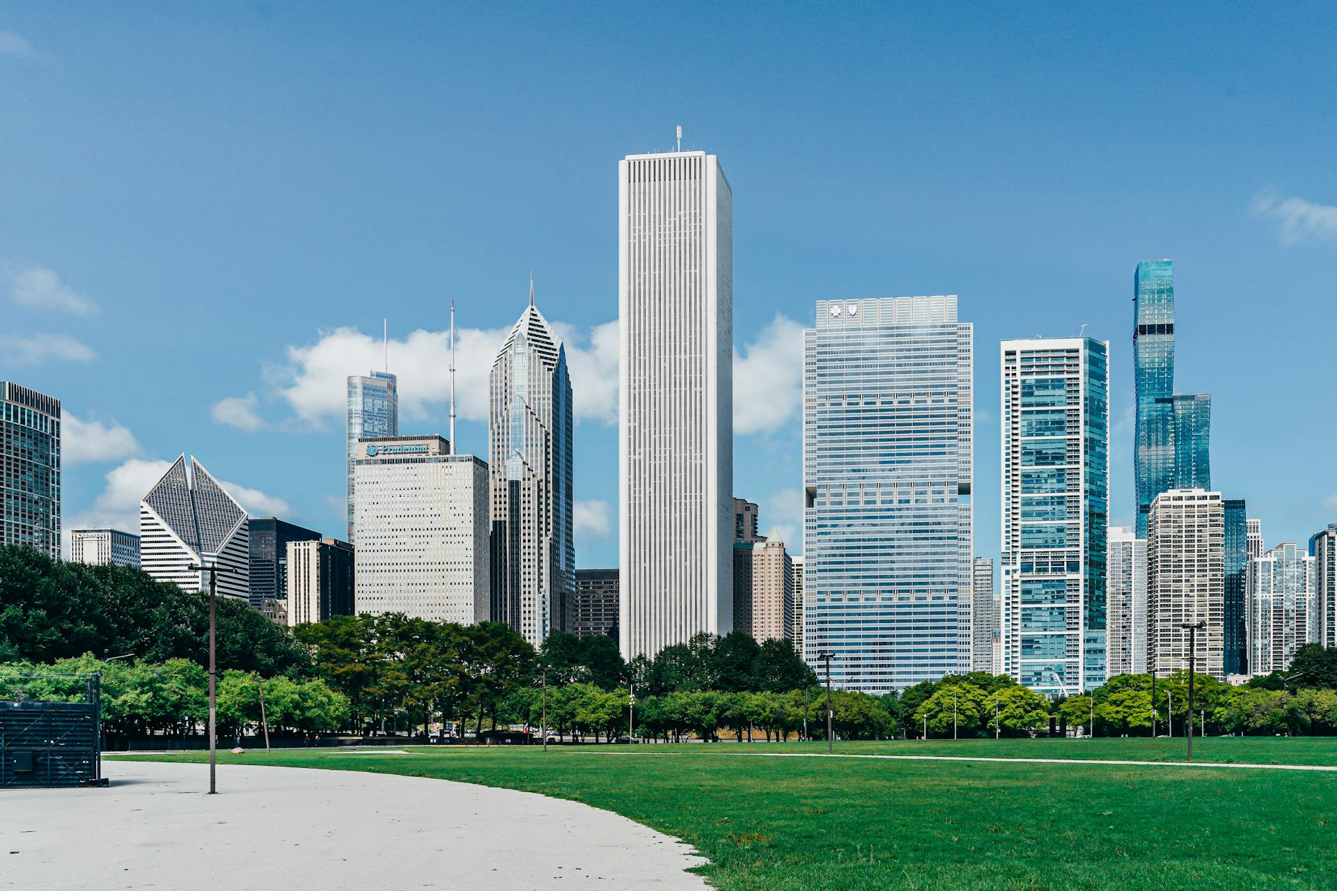 Modern city district with skyscrapers near green lawn