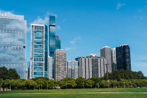 Free Exterior of modern glass skyscrapers built near lush city park under cloudless blue sky Stock Photo