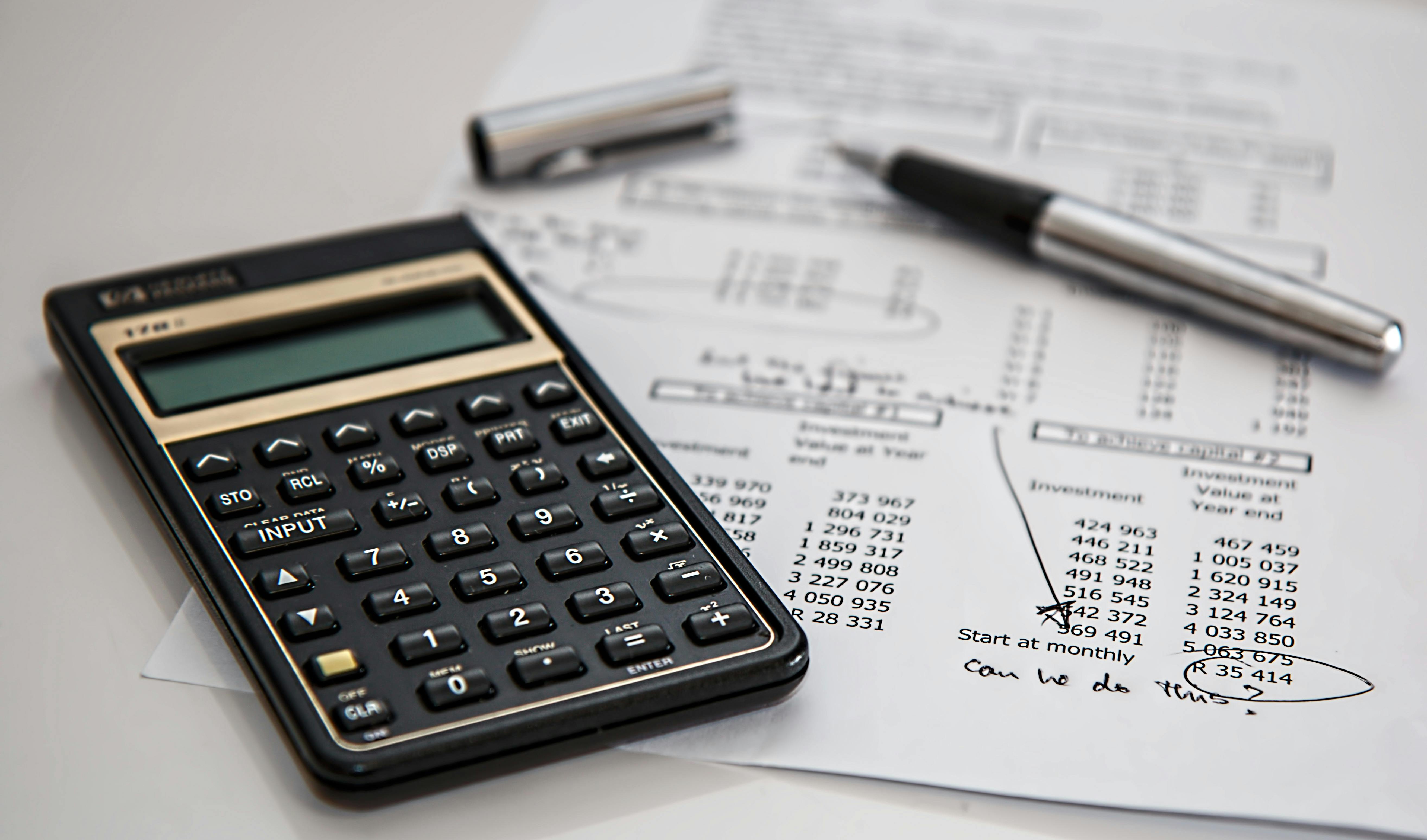A pen and a calculator placed on a document