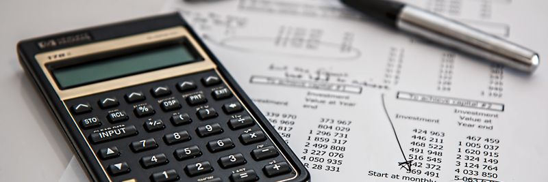Close-up of financial documents with calculator and pen, ideal for business management themes.