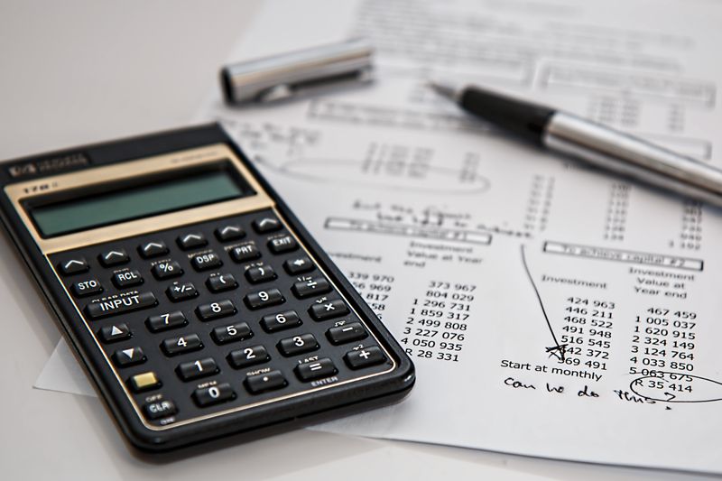 Close-up of financial documents with calculator and pen, ideal for business management themes.