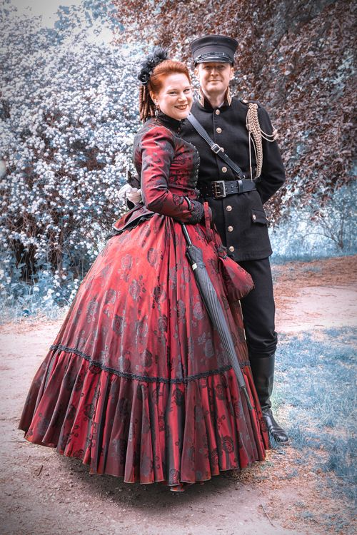 Free A couple in Victorian-style attire posing in an outdoor photo shoot. Stock Photo