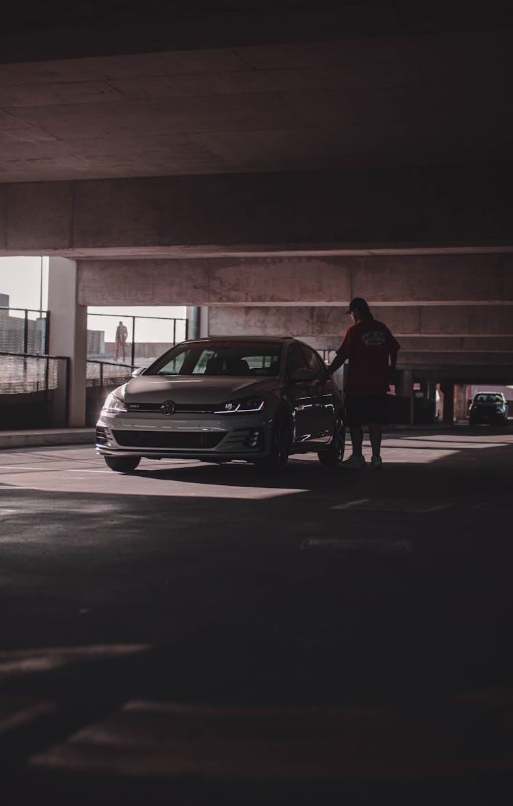 Photo Of A Person Entering A Car In A Parking Lot