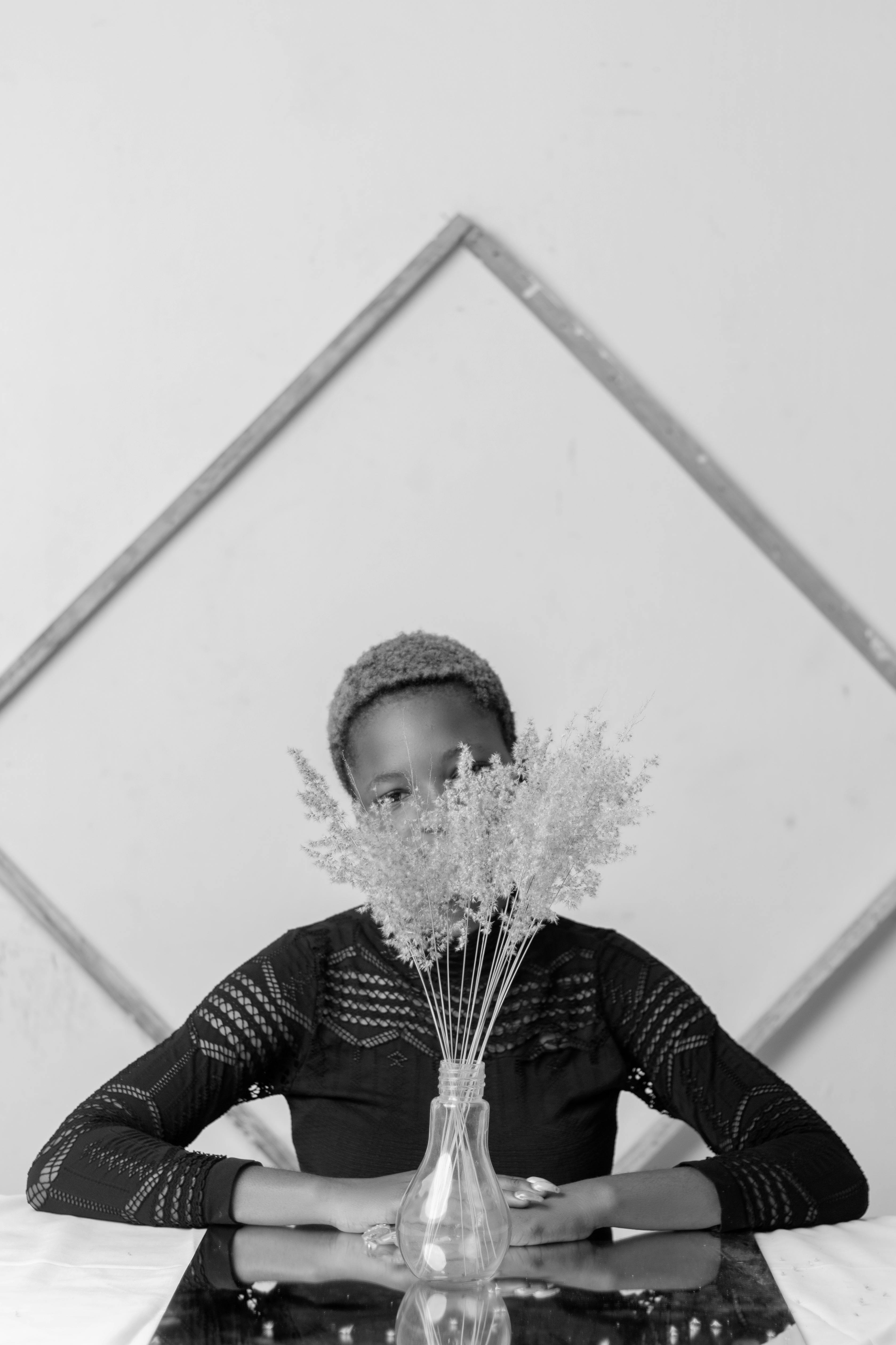 grátis Mulher Negra Anônima Sentada Perto De Um Vaso De Flores E De Uma Janela Em Casa Foto profissional