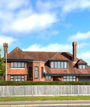 A beautiful brick house with traditional architecture in Drayton, England, under a clear blue sky.