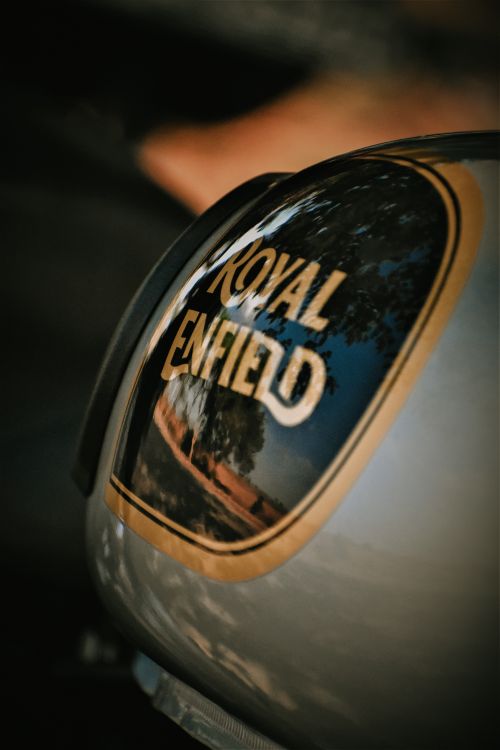 Free Reflective close-up of a Royal Enfield motorcycle tank capturing ambient reflections. Stock Photo