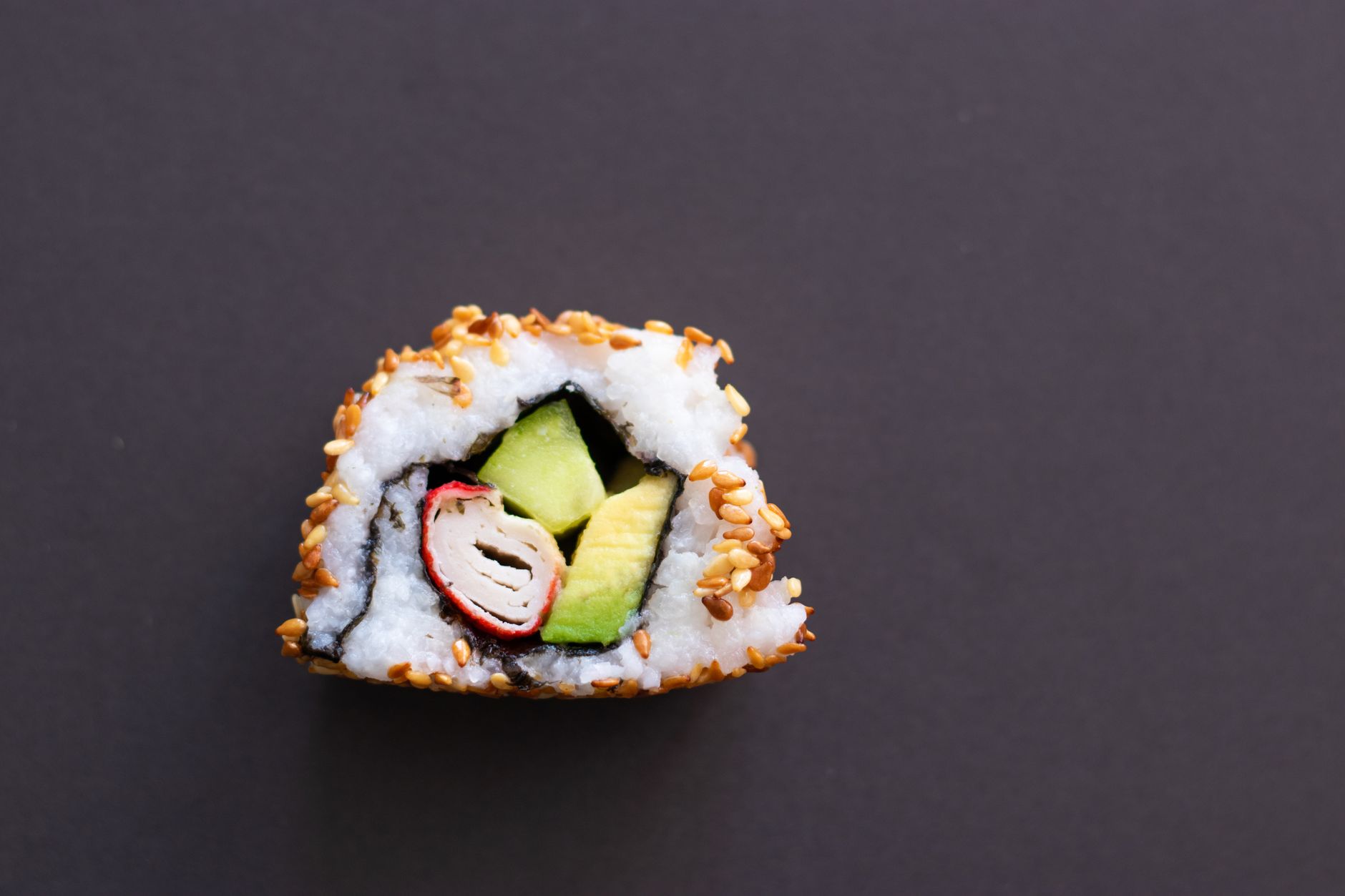 Hands rolling futomaki sushi with bamboo mat in a home kitchen