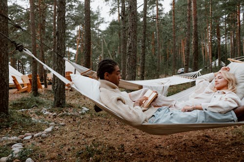 Free Photo of a Man Reading a Book Beside a Woman with Blond Hair Stock Photo