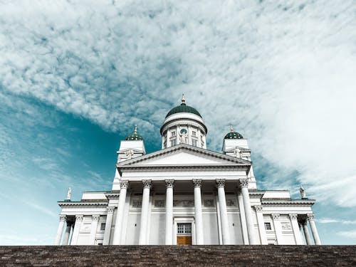 Majestic white cathedral with domes and pillars against blue sky