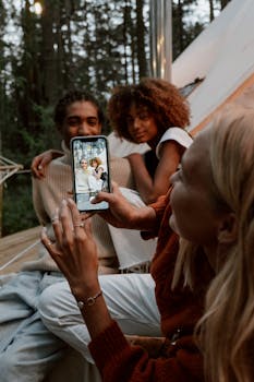 Group of friends taking a picture together in a cozy outdoor setting. Perfect for lifestyle themes.