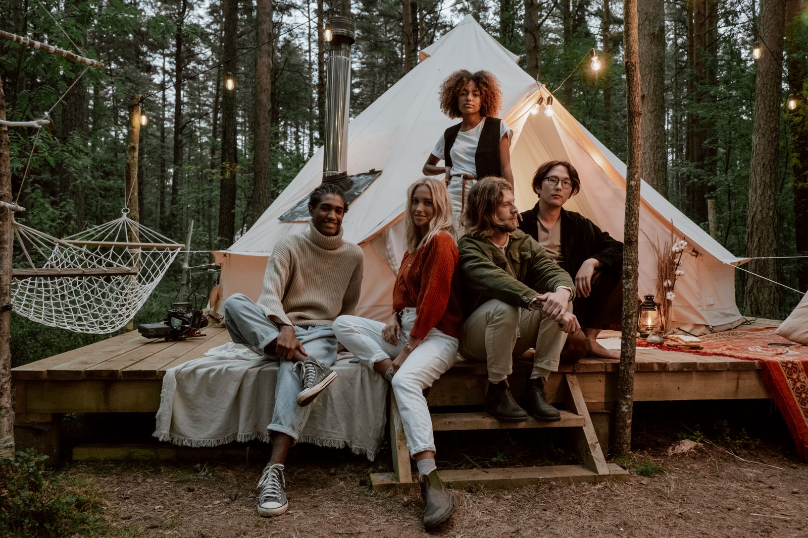 Colleagues gathered outside a canvas lodge in the woods - photo by cottonbro studio on Pexels