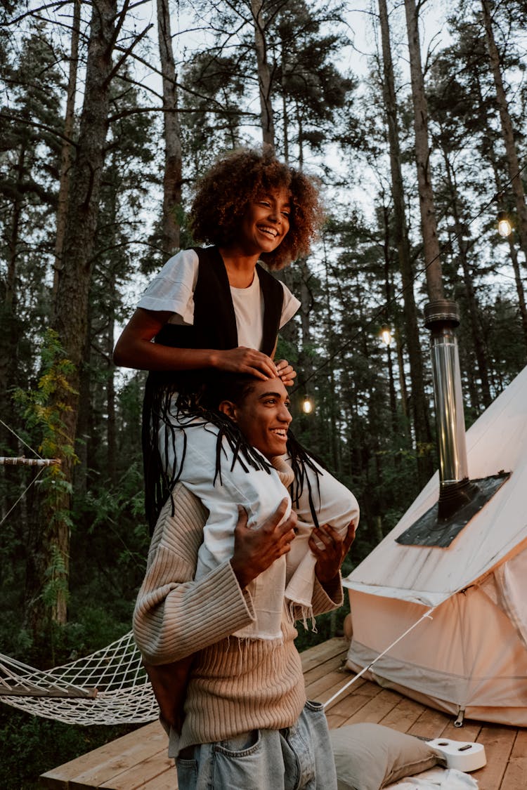 Photo Of A Man Carrying A Woman With Curly Hair