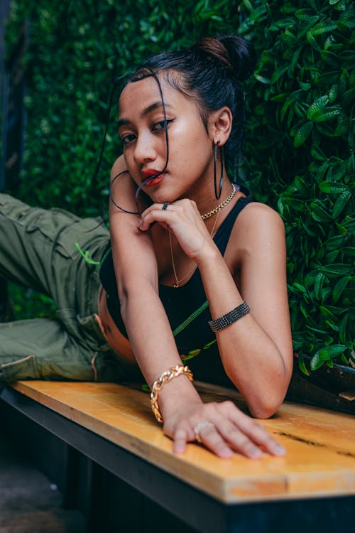 Woman in a Black Tank Top Posing with Her Hand on Her Chin