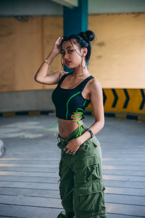 Free Woman in a Black and Green Top Posing with Her Hand on Her Head Stock Photo