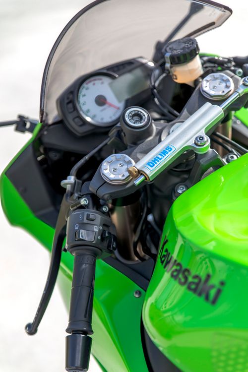 Free Detailed close-up view of a green Kawasaki motorcycle dashboard showcasing handlebars and instruments. Stock Photo