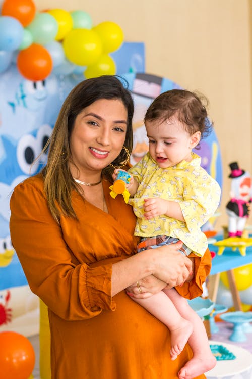 Mother in a Brown Dress Carrying Her Child