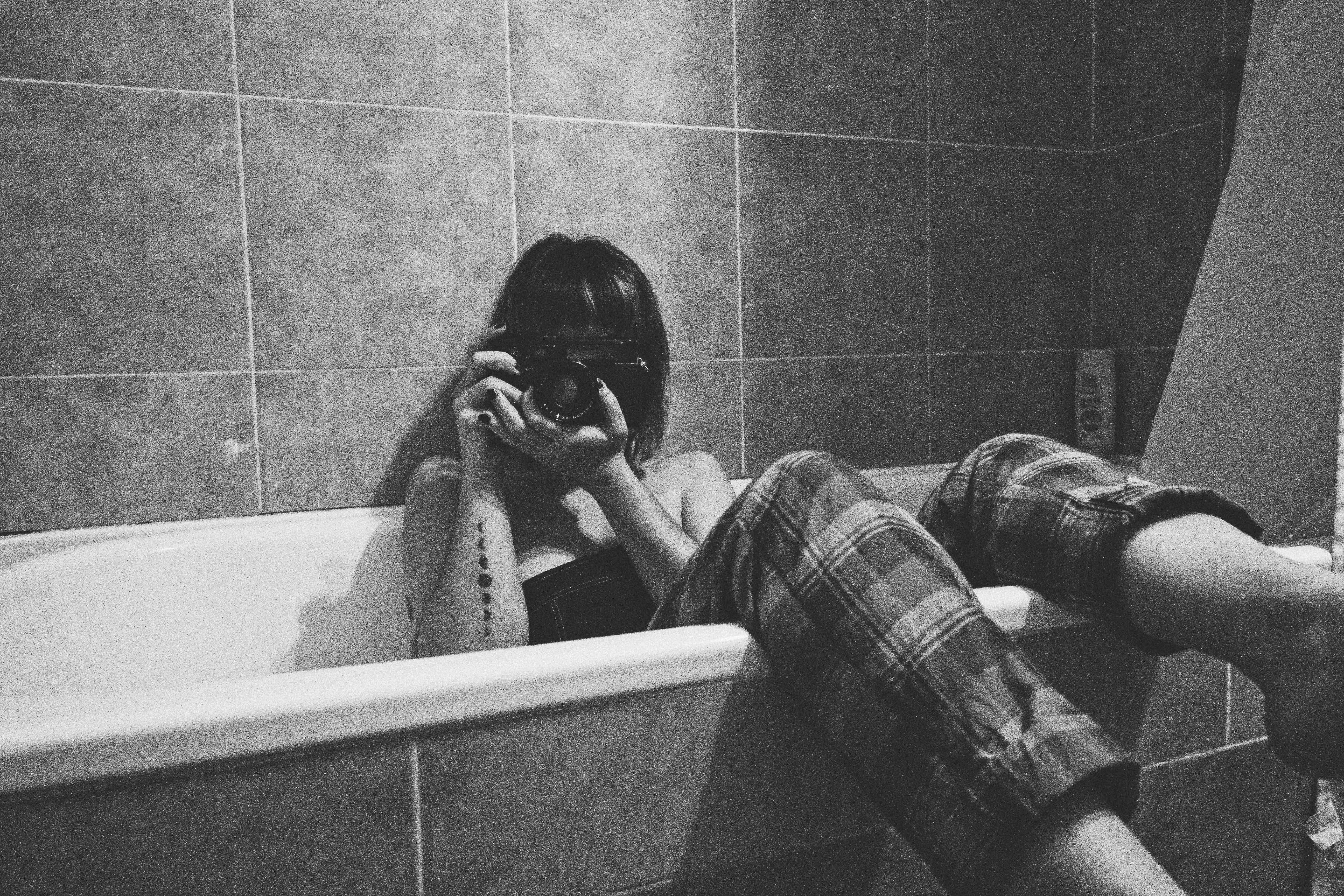 Woman Sitting in Bathtub and Photographing · Free Stock Photo