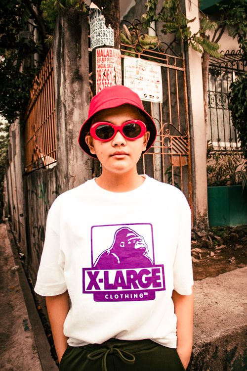 Free Stylish adult in red hat and sunglasses in urban backdrop, showcasing modern fashion. Stock Photo