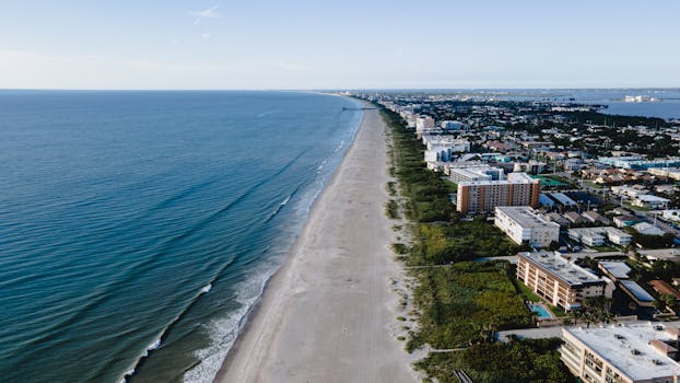 A stunning aerial view of a seaside city with sandy beaches and urban waterfront buildings.