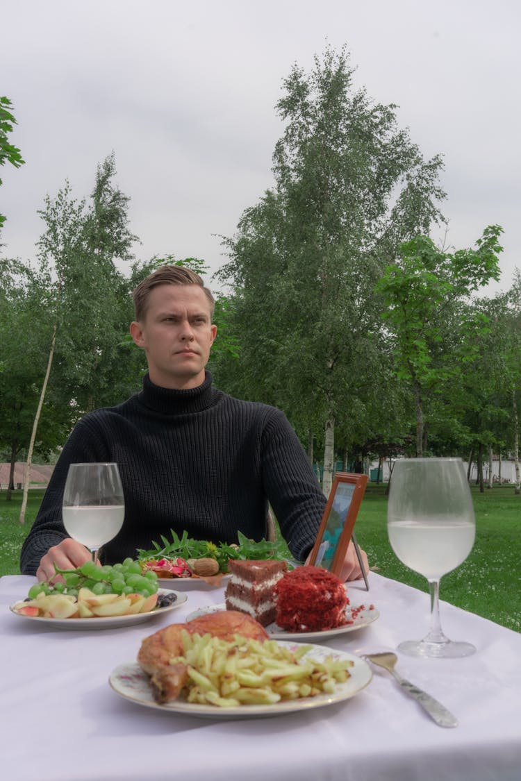 Serious Man Sitting At Table With Food