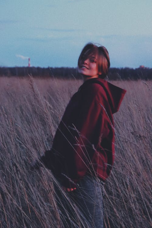 A Woman Standing in the Grass Field