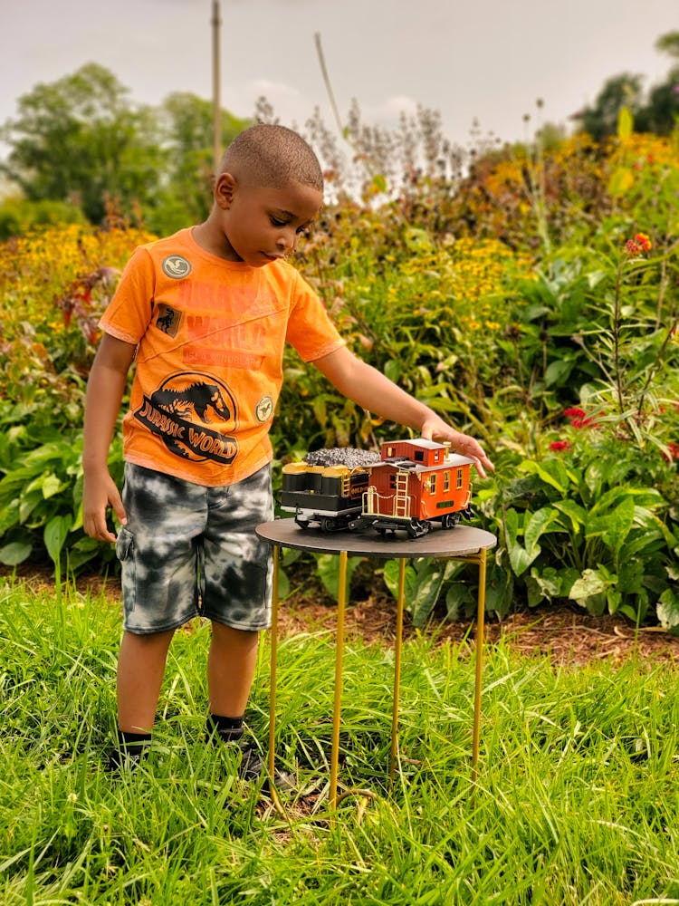 Boy With Toys In Garden