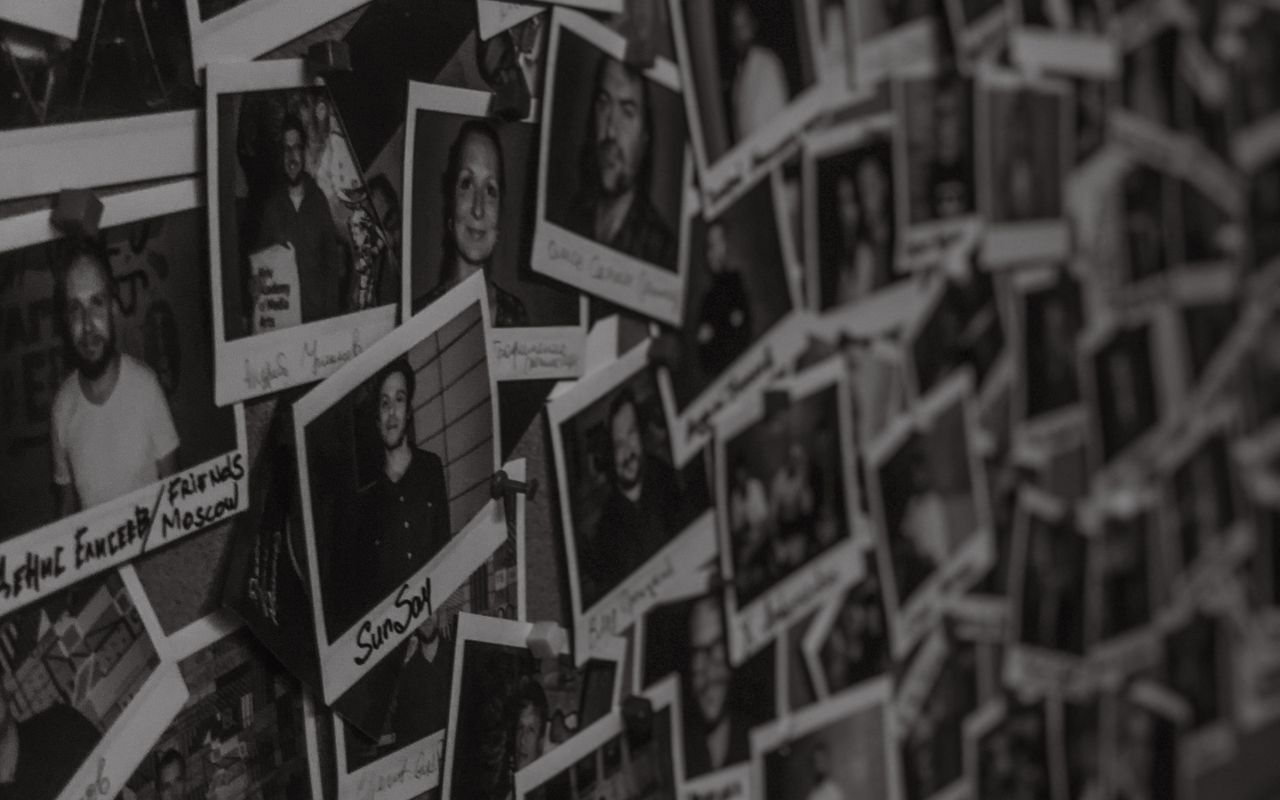 a wall filled with black and white polaroid photos captured in a vinta