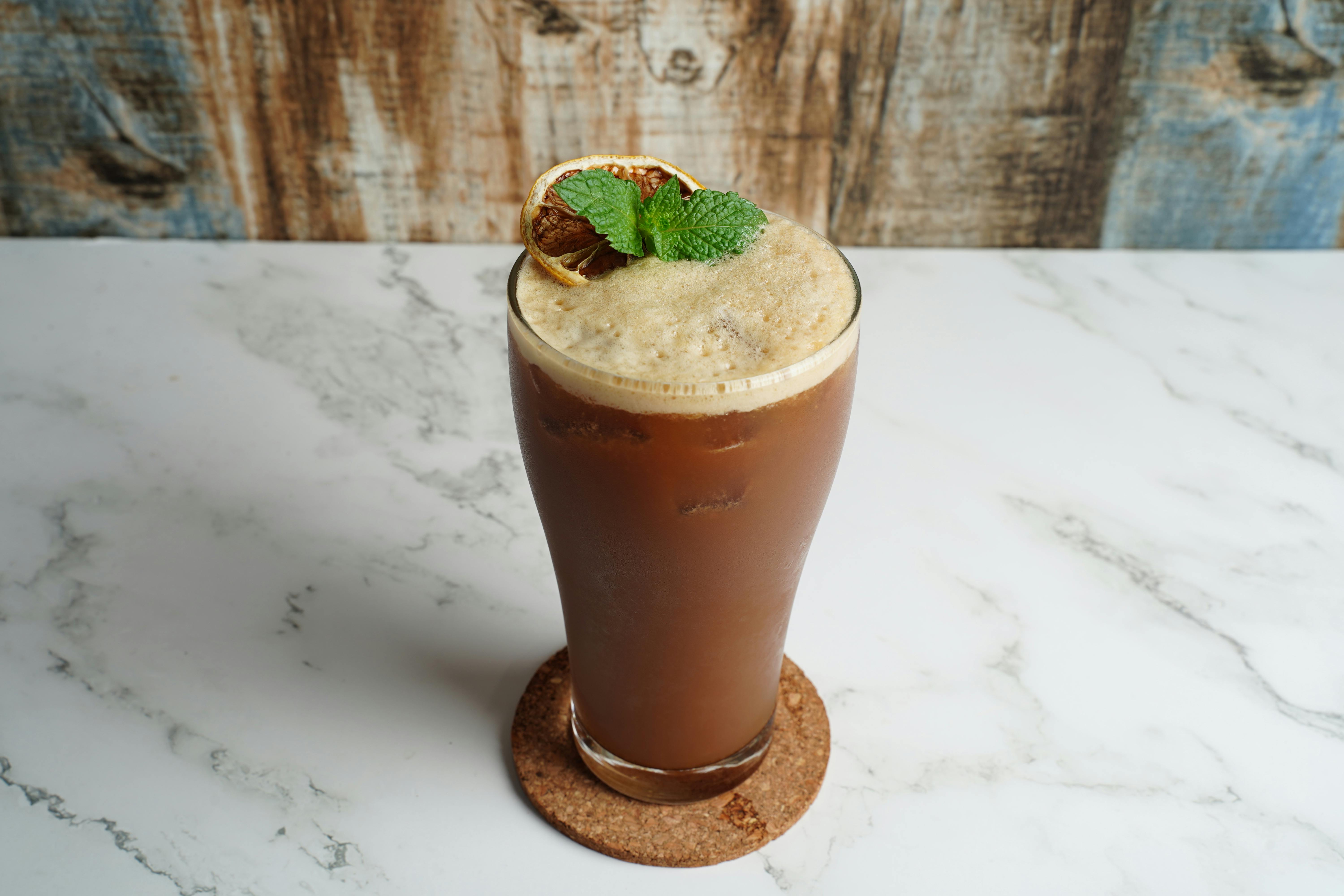 Delicious iced coffee topped with fresh mint and lime, perfect for a refreshing break.
