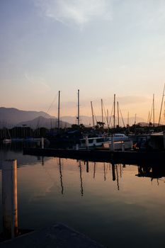 黄昏时分，停泊在码头上的帆船，以美丽的日落为背景，构成了一幅宁静的景色