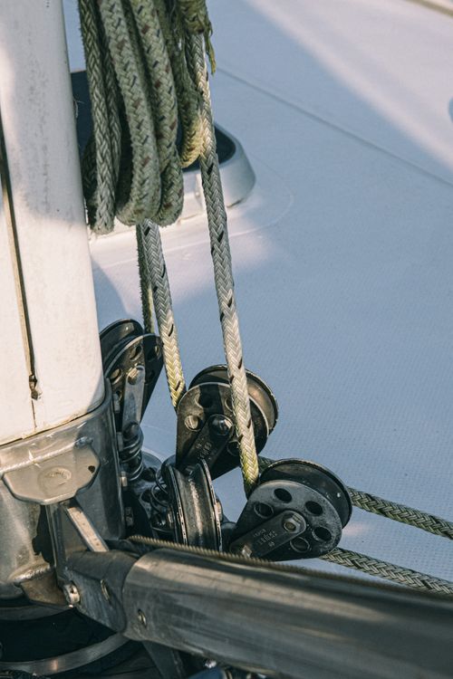 Free Metal mechanism of sailing boat with rope placed on edge of white bow in sunlight in daytime in summer outside Stock Photo