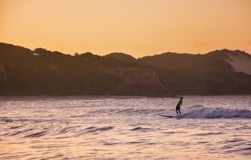 Person Surfing on Sea