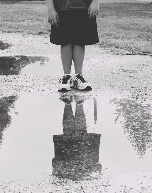 Free Grayscale Photo of a Person Standing on Wet Road Stock Photo