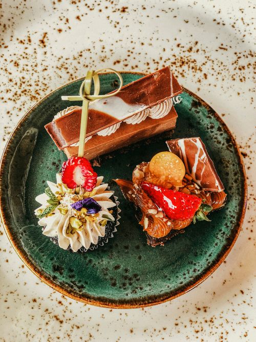 Free Assorted gourmet pastries on a rustic green plate. Perfect for food photography needs. Stock Photo