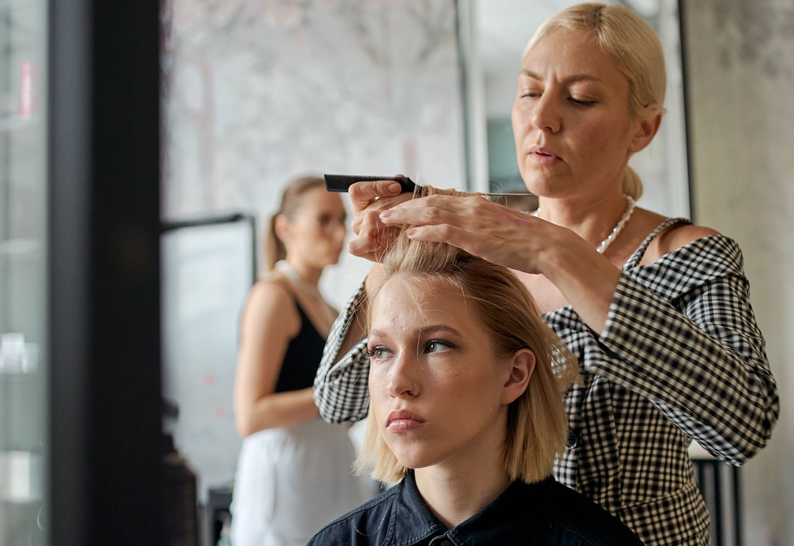 Female hairstylist smoothing a client's hair with an iron