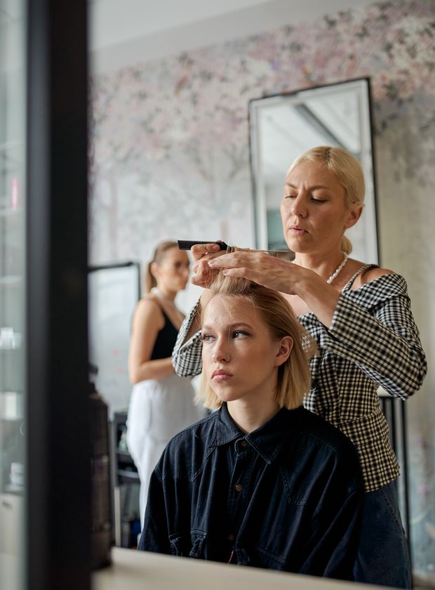 Female hairstylist smoothing a client's hair with an iron