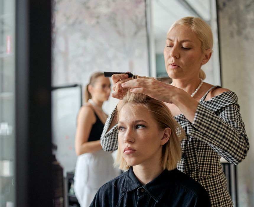 Female hairstylist smoothing a client's hair with an iron