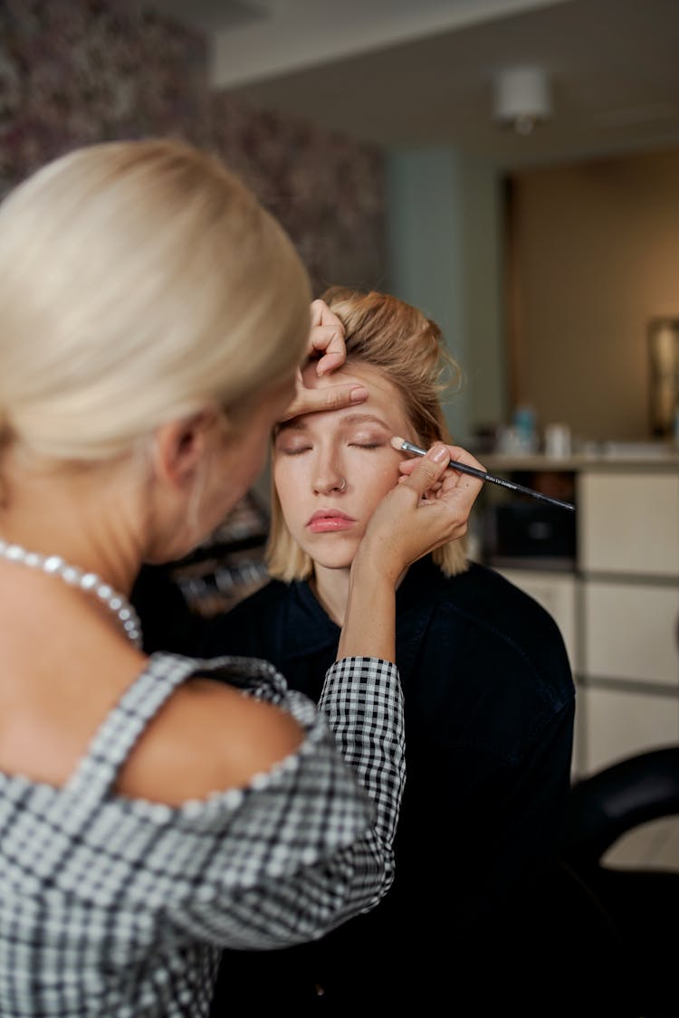 Unrecognizable Beauty Master Doing Makeup To Female Model In Salon