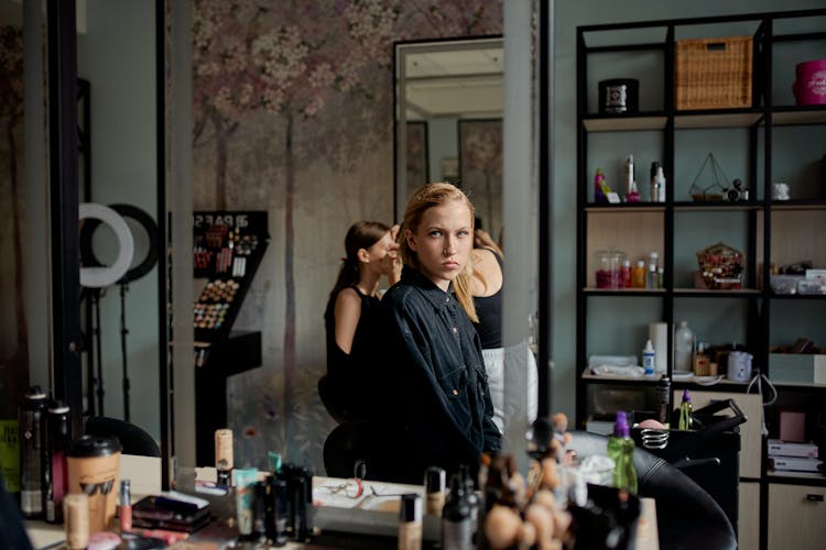 Concentrated Model Reflecting In Mirror Of Beauty Salon