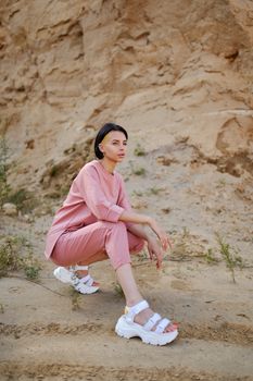 Side view of young female in trendy outfit and contemporary footwear looking away in mounts